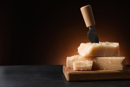 Delicious parmesan cheese with knife on black table. Space for textの写真素材