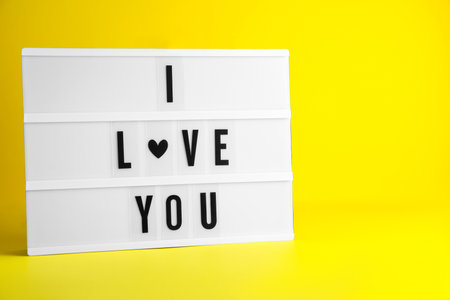 Decorative lightbox with phrase I love You on yellow background. Space for textの写真素材