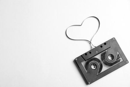 Music cassette and heart made with tape on white background, top view. Listening love songの写真素材
