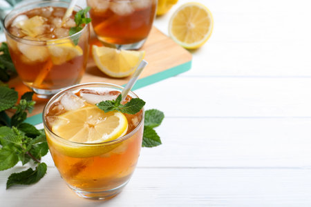 Delicious iced tea in glass on white wooden table, space for textの写真素材