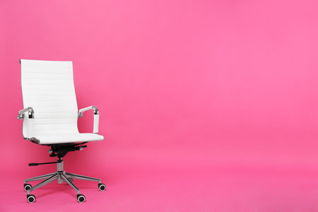Comfortable office chair on pink background, space for textの写真素材