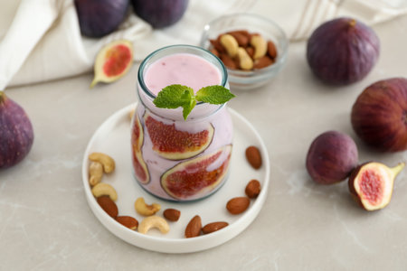 Delicious fig smoothie in glass jar on light tableの写真素材