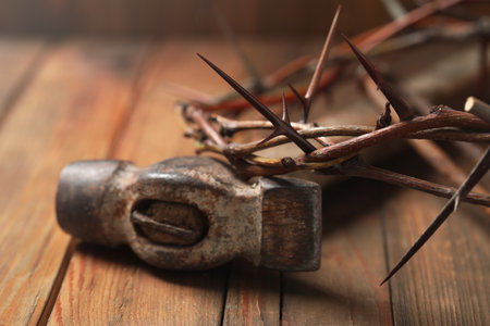 Crown of thorns and hammer on wooden table, closeup. easter attributesの写真素材