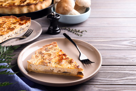 Delicious pie with mushrooms and cheese served on wooden tableの写真素材