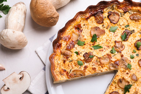 Delicious pie with mushrooms and cheese served on light table, flat layの写真素材