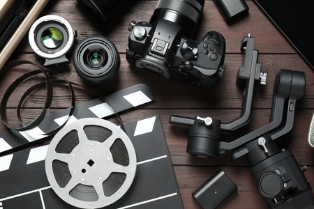Flat lay composition with camera and video production equipment on brown wooden backgroundの写真素材