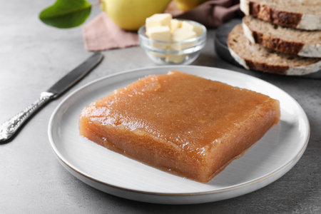 Delicious quince paste on gray table, closeup