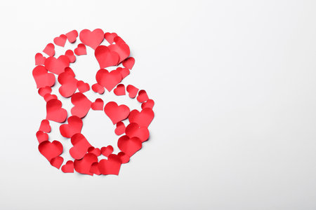 Number 8 made with red paper hearts on white background, top view. International Women's dayの写真素材