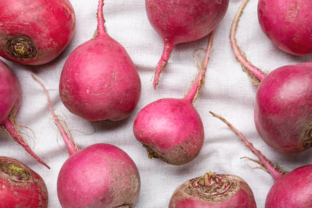 Red turnips on white fabric, flat lay