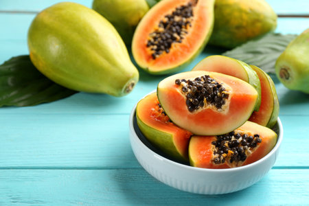 Fresh ripe papaya fruits on turquoise wooden tableの写真素材
