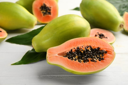 Fresh ripe papaya fruits on white wooden tableの写真素材