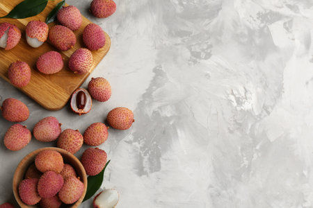 Fresh ripe lychee fruits on light gray table, flat lay. Space for textの写真素材