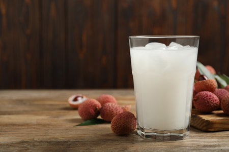 Lychee juice and fresh fruits on wooden table. Space for textの写真素材