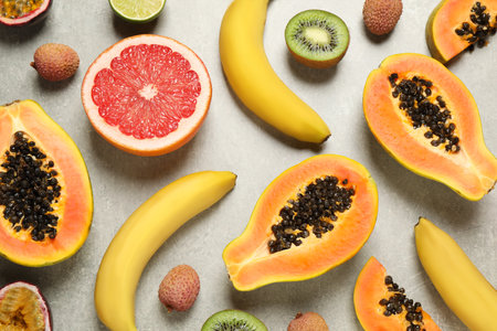 Fresh ripe papaya and other fruits on light gray table, flat layの写真素材