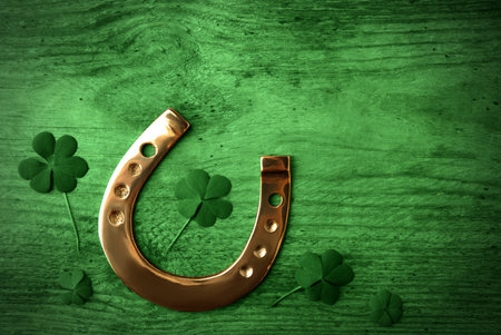 Clover leaves and horseshoe on green wooden table, flat lay. St. Patrick's Day celebrationの写真素材