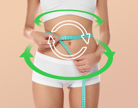 Metabolism concept. Young woman with perfect body on beige background, closeupの写真素材