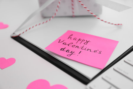 Memory sticker with phrase Happy Valentine's Day on clipboard at table, closeupの写真素材
