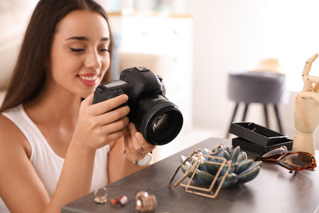 Young photographer taking picture of jewelry indoors, closeupの写真素材