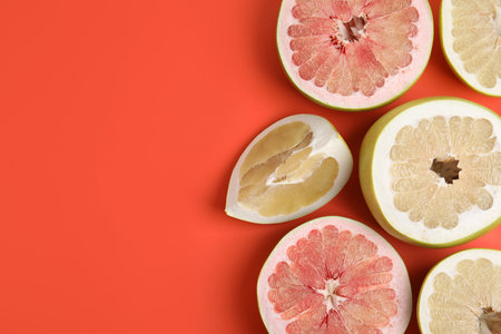 Fresh cut pomelo fruits on red background, flat lay. Space for textの写真素材