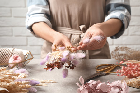 Florist making bouquet of dried flowers at gray stone table, closeupの写真素材