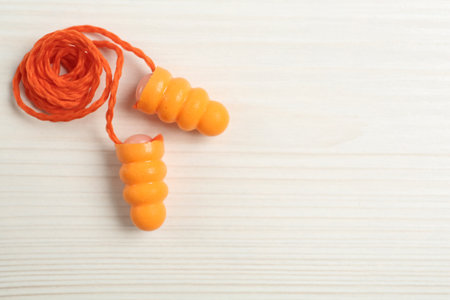 Pair of ear plugs on white wooden background, flat lay. Space for textの写真素材