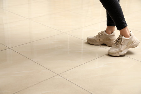 Woman standing on ceramic floor, closeup. Space for textの写真素材