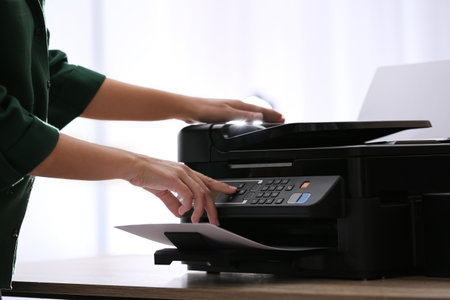 Employee using modern printer in office, closeup