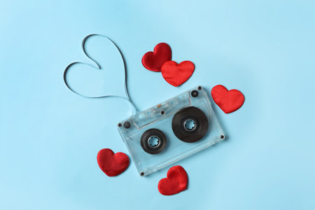 Music cassette and red hearts on light blue background, flat lay. Listening love songの写真素材