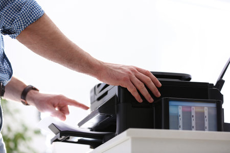 Employee using modern printer in office, closeupの写真素材