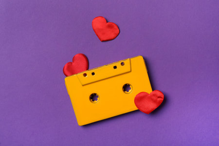 Music cassette and red hearts on purple background, flat lay. Listening love songの写真素材
