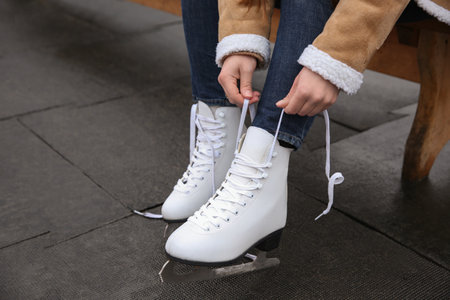 Woman lacing figure skate outdoors, closeup viewの写真素材