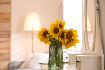 Beautiful bouquet of sunflowers in vase on white table indoors. Space for textの写真素材