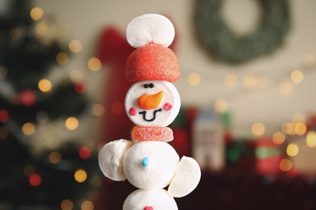 Funny snowman made of marshmallows against blurred Christmas tree, closeupの写真素材