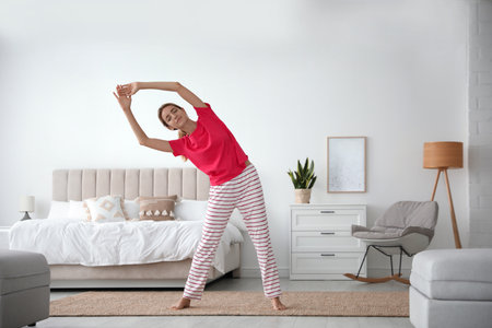 Young woman doing gymnastics at home. morning fitnessの写真素材