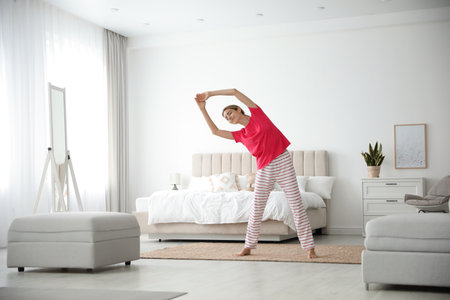 Young woman doing gymnastics at home. morning fitnessの写真素材