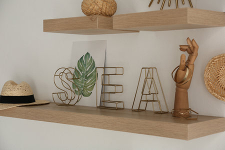 Wooden shelves with women's accessories and different decorative elements on light wallの写真素材