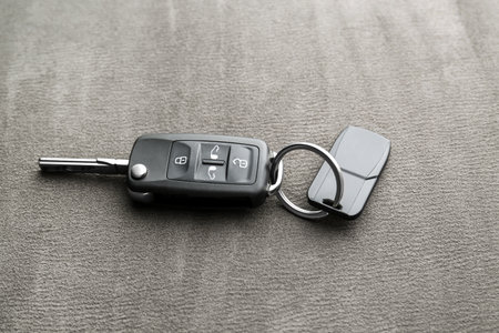 Modern car flip key with trinket on gray fabric