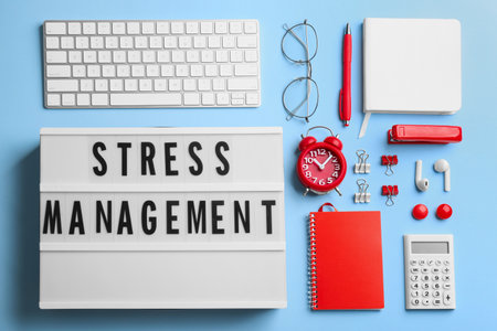 Flat lay composition of lightbox with phrase Stress Management on light blue backgroundの写真素材