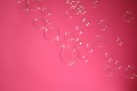 Beautiful translucent soap bubbles on pink backgroundの写真素材