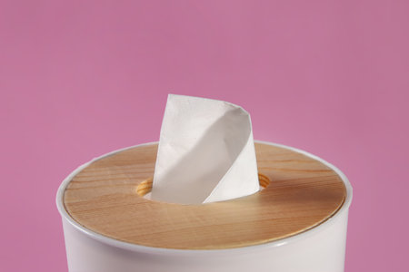 Holder with paper tissue on pink background, closeupの写真素材
