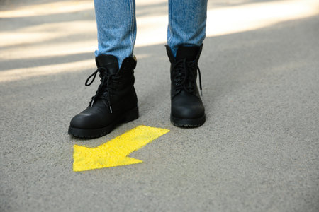Person standing near arrow on asphalt, closeupの写真素材