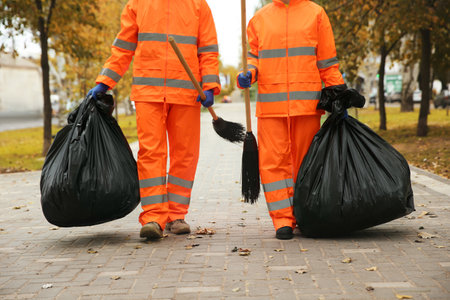 Street cleaner with brooms and garbage bags outdoors on autumn dayの写真素材