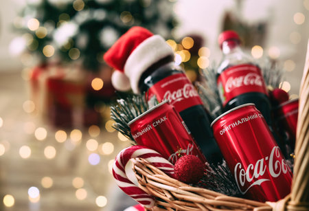 MYKOLAIV, UKRAINE - January 01, 2021: Basket with Coca-Cola drinks against blurred Christmas lights, closeupのeditorial素材