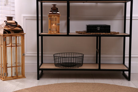 Stylish shelving unit with different decor near white wall indoors. interior design