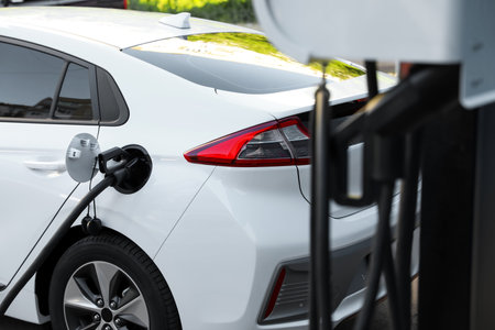 Charging modern electric car from station outdoorsの写真素材