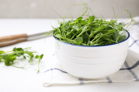 Bowl with fresh microgreens on white table, closeupの写真素材