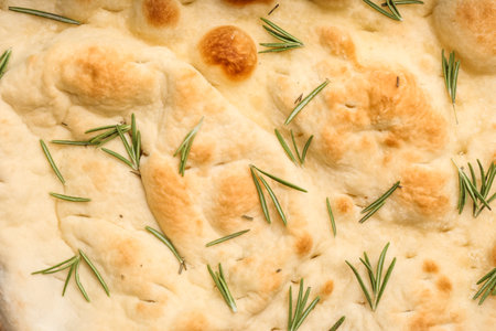 Traditional Italian focaccia bread with rosemary as background, closeupの写真素材