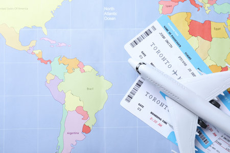 Toy airplane and tickets on world map, flat lay. travel agency conceptの写真素材
