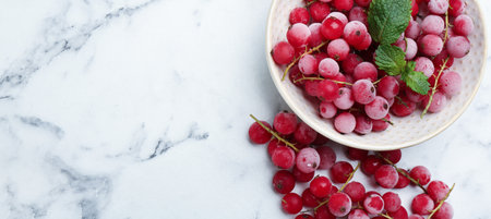 Tasty frozen red currants on white marble table, flat lay. Space for textの写真素材