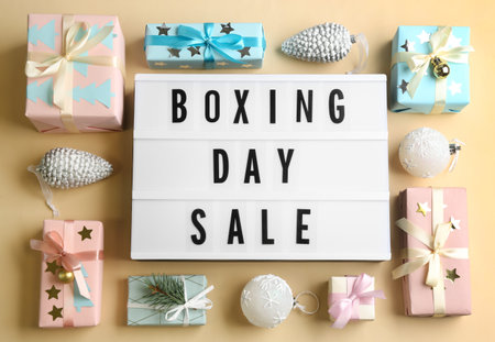 Lightbox with phrase BOXING DAY SALE and Christmas decorations on beige background, flat layの写真素材